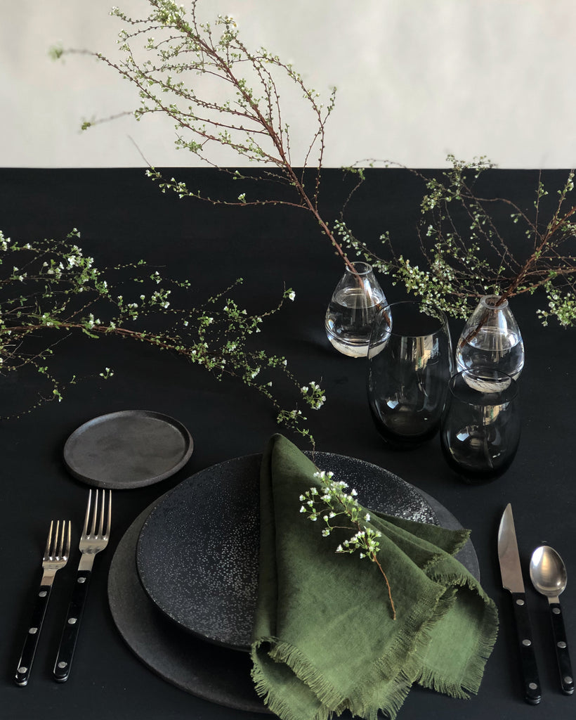 raw edge linen napkins dark forest green on black table setting