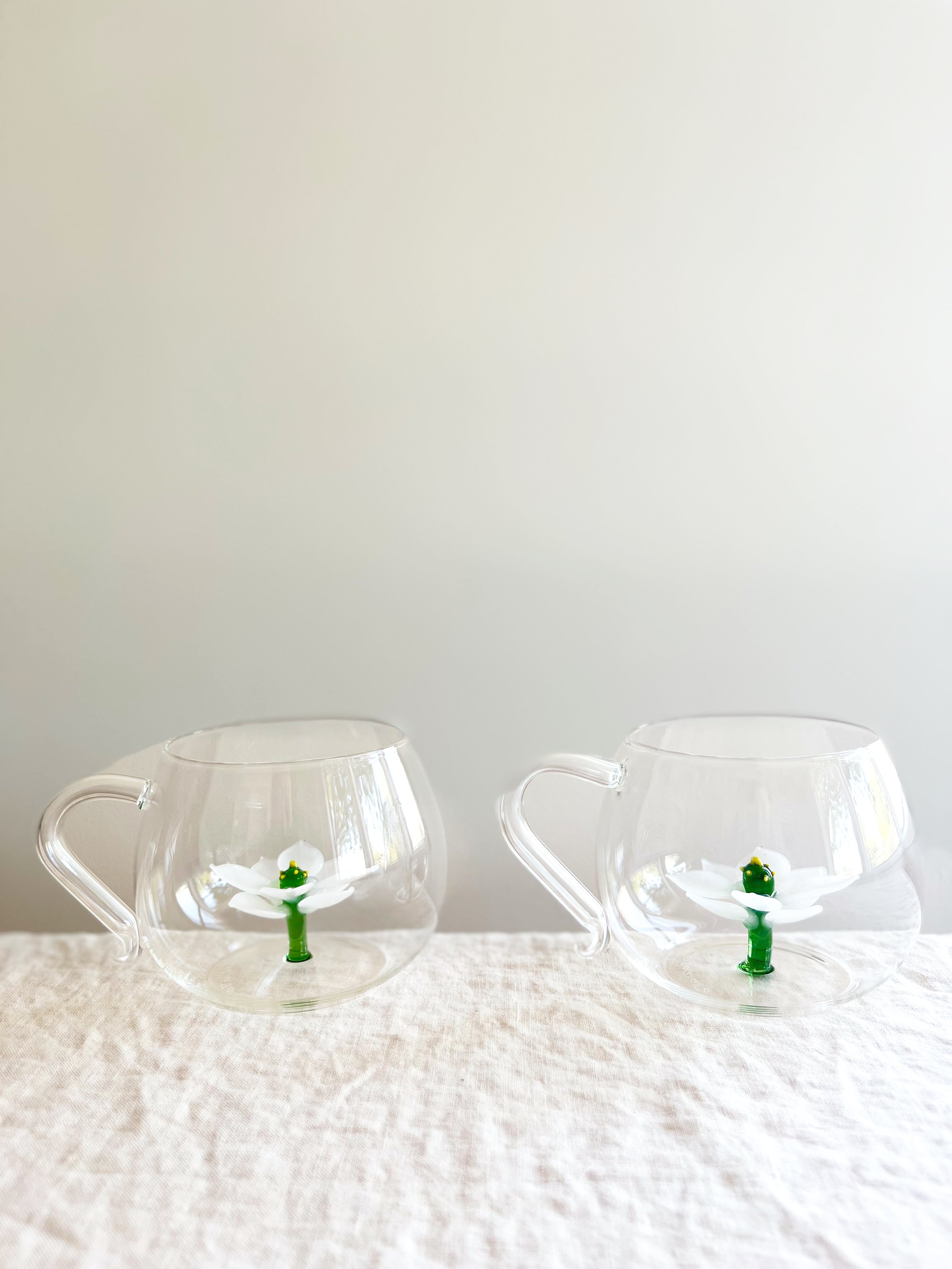 clear hand blown glass tea cup with white glass lotus flower in bottom