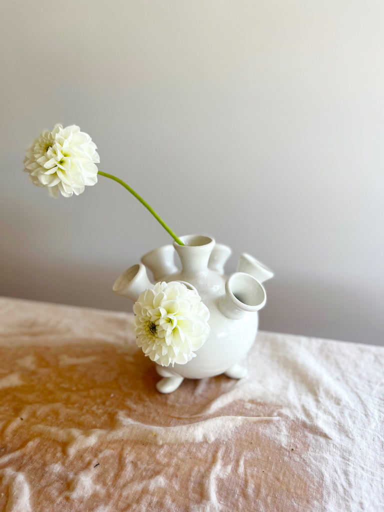 white ceramic footed tulipiere with single flower