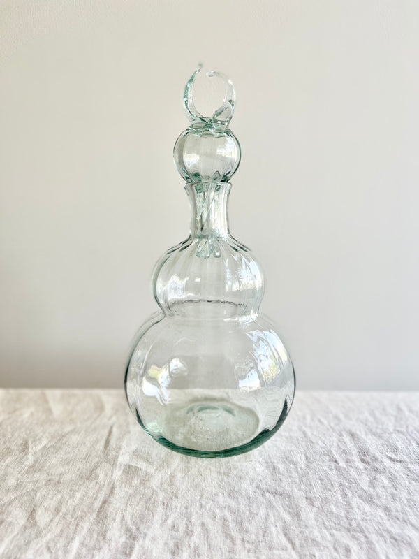 decanter made of clear blown glass on table