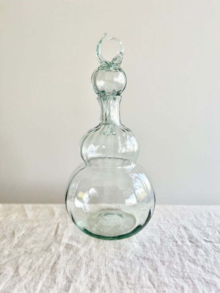 decanter made of clear blown glass on table