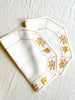octagonal white linen placemat with gold embroidery 19.5" by 16"
