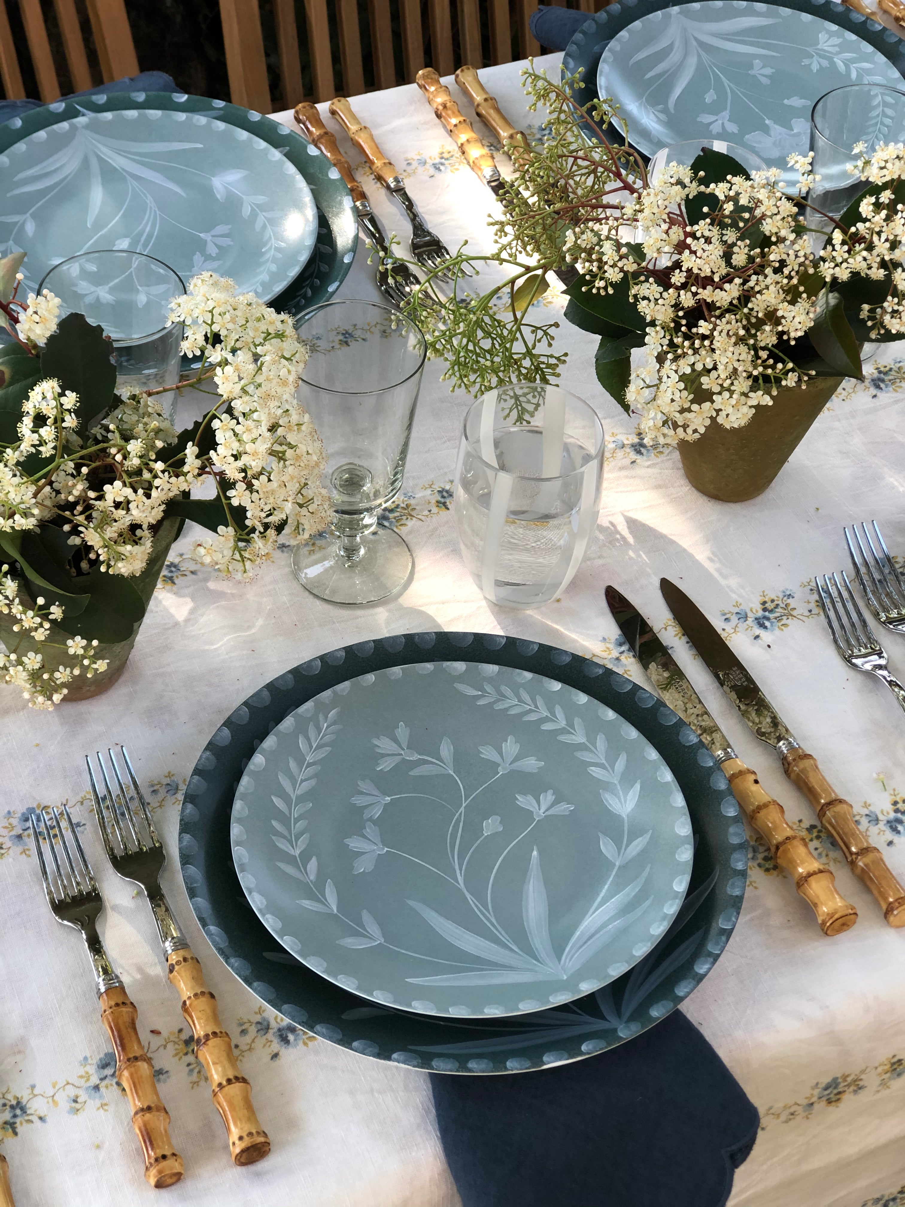 white tablecloth with blue and yellow floral stripe pattern with placesetting