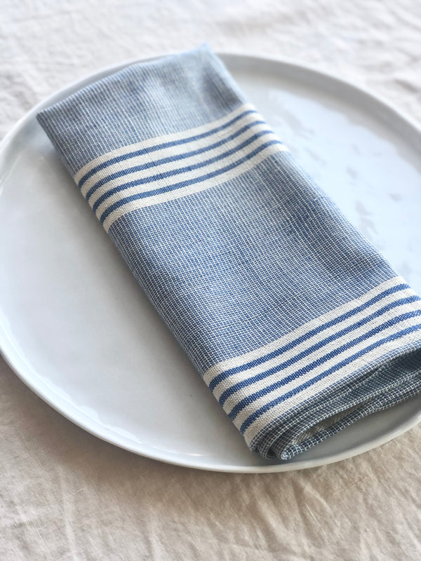 blue and white woven cotton napkins 19 inches square folded on plate
