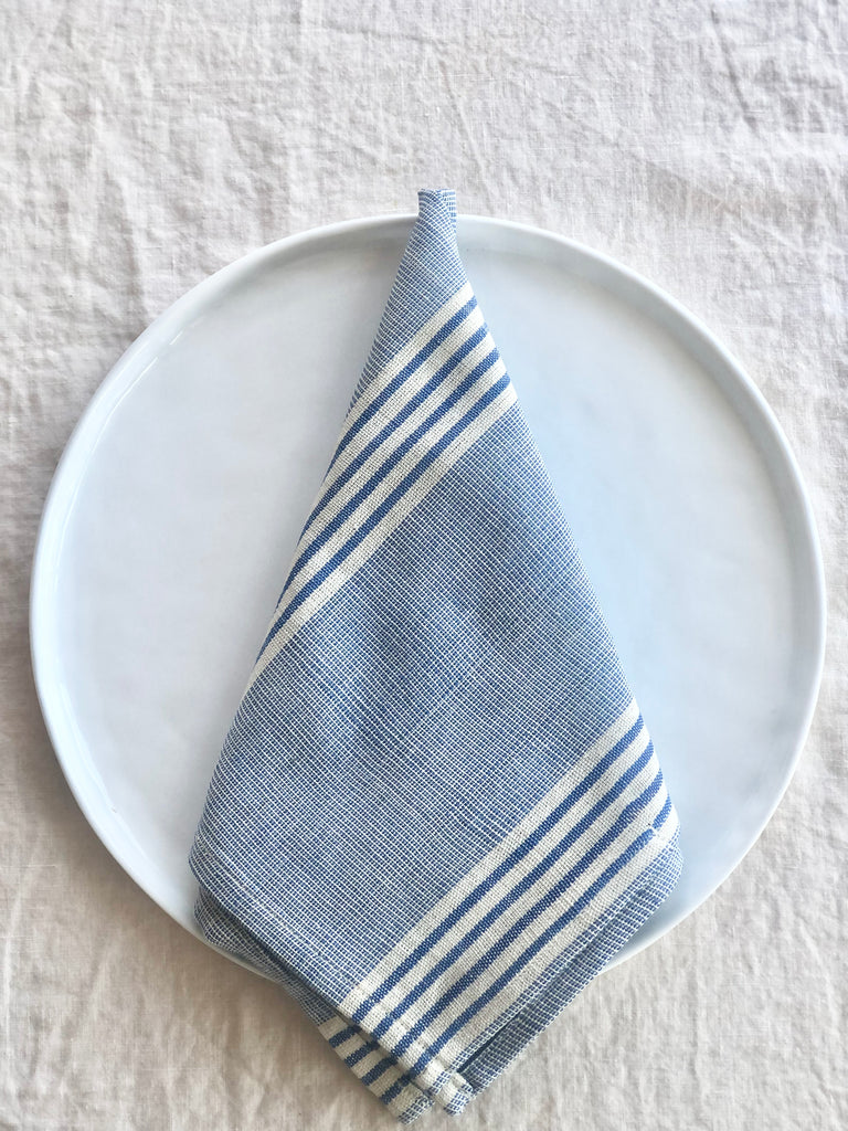 blue and white woven cotton napkins 19 inches square on white table