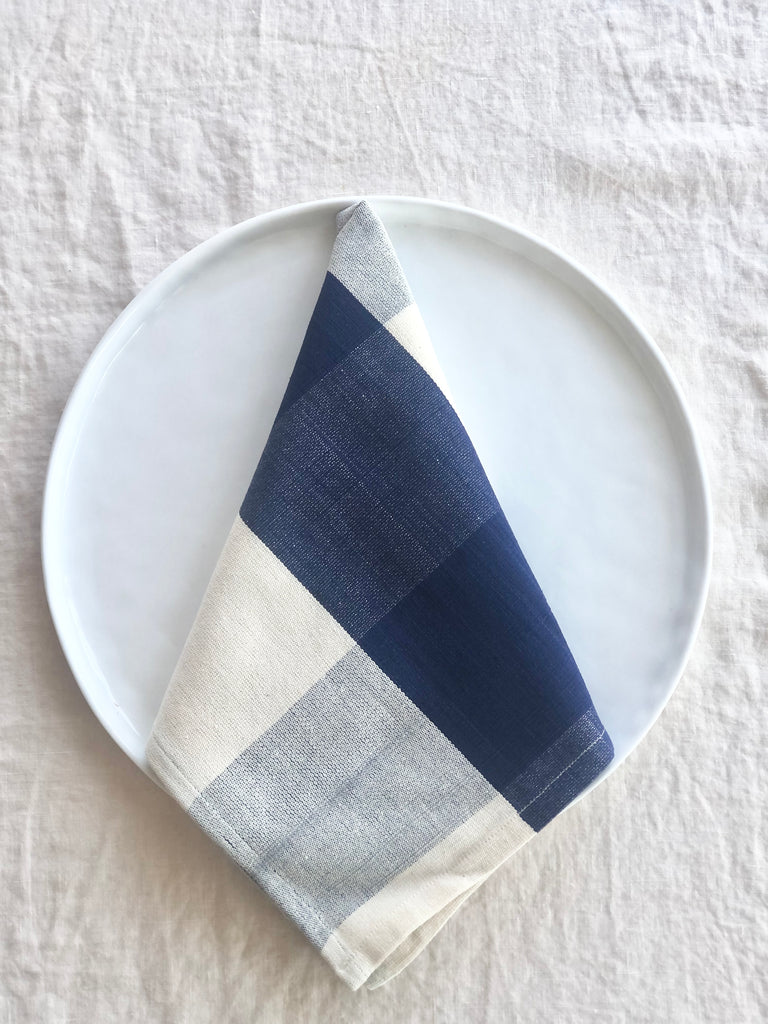 checkered blue and white napkins 19" square folded on plate