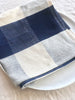 checkered blue and white napkins 19" square on white table