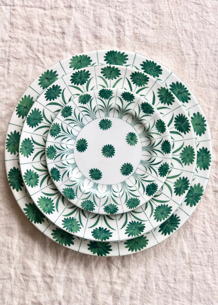 ceramic dinner plate with green daisy pattern in place setting