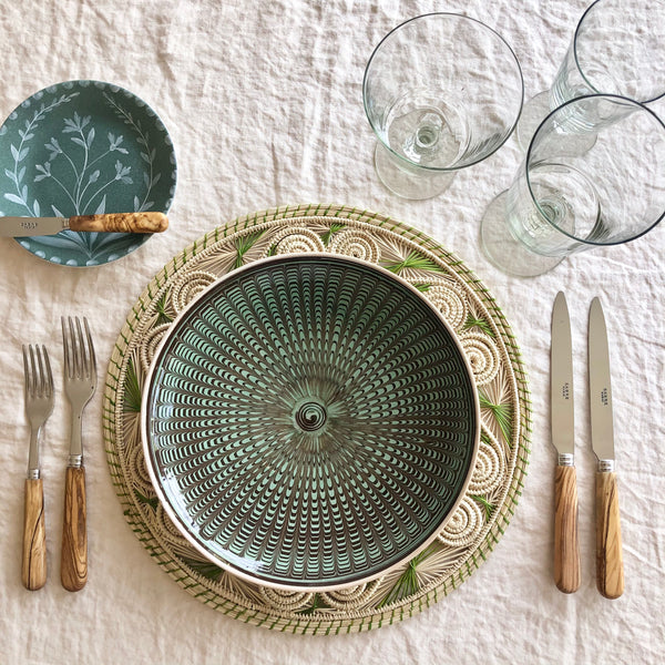green and black dinner plate with radial peacock pattern  with placesetting