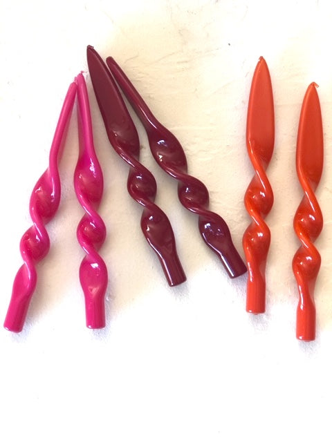 bright pink twisted taper candles 11 inches tall shown in pink burgandy and orange