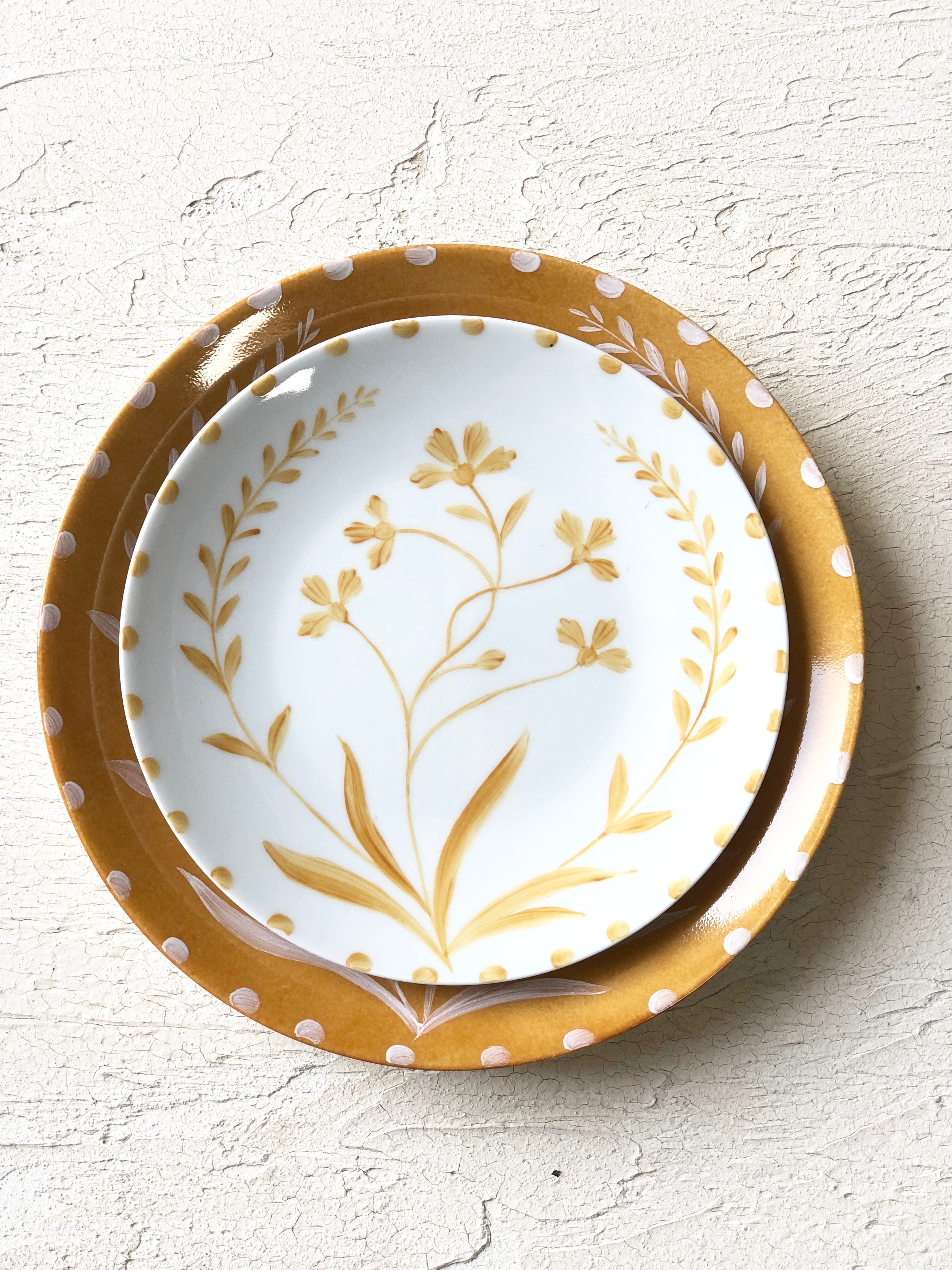white salad plate with yellow floral pattern on top of yellow plate