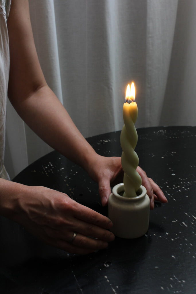 photo of white hand-crafted twist taper candles with flame lit