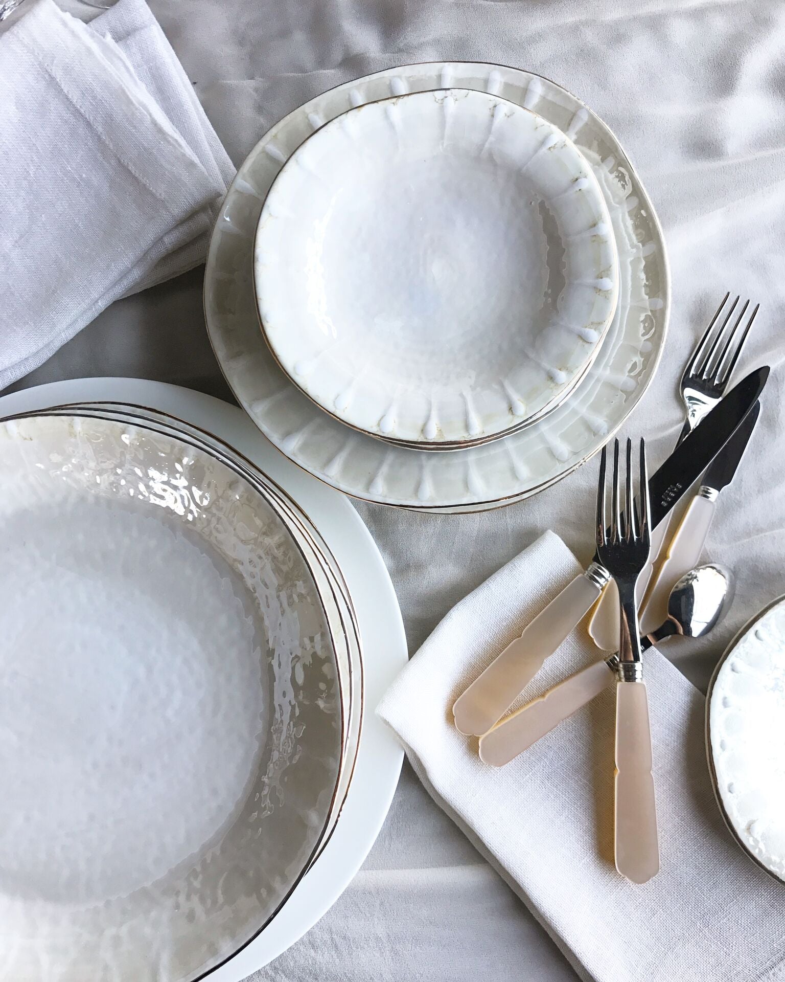 sabre stainless steel flatware set with cream resin handle on white tablecloth