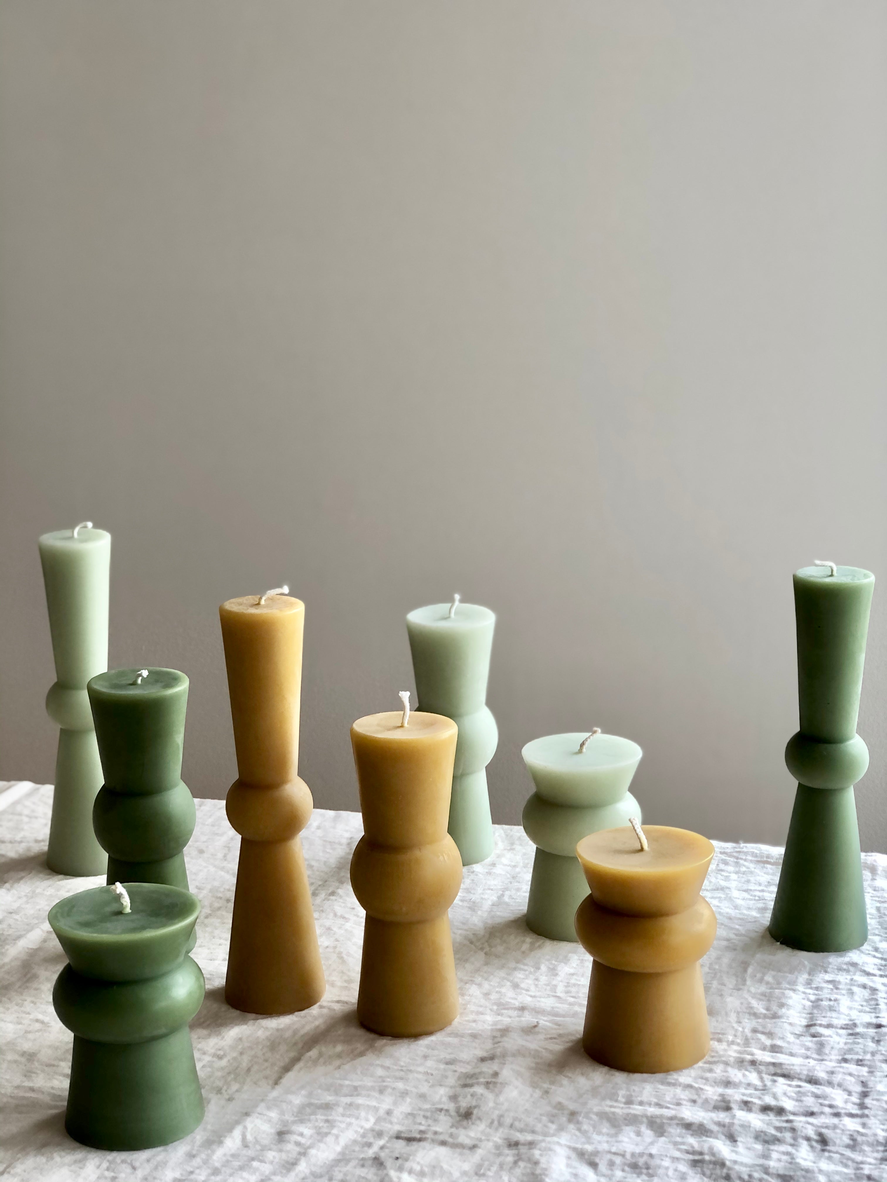 assorted natural totem candles on a white table