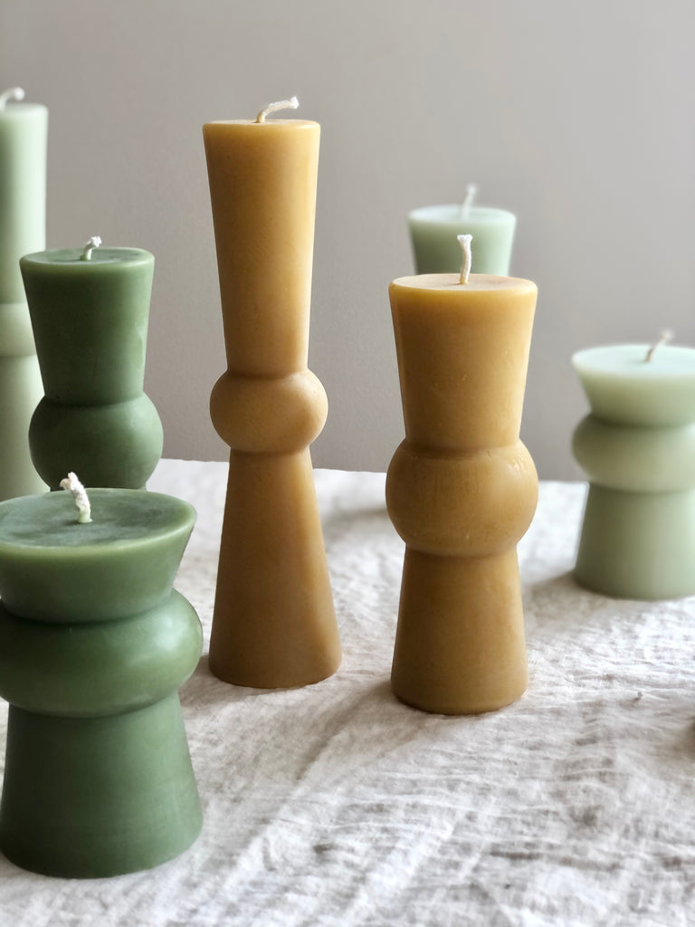 green and natural pillar candles all sizes on table