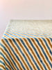 cotton tablecloths green with brown and blue stripes draped over a table