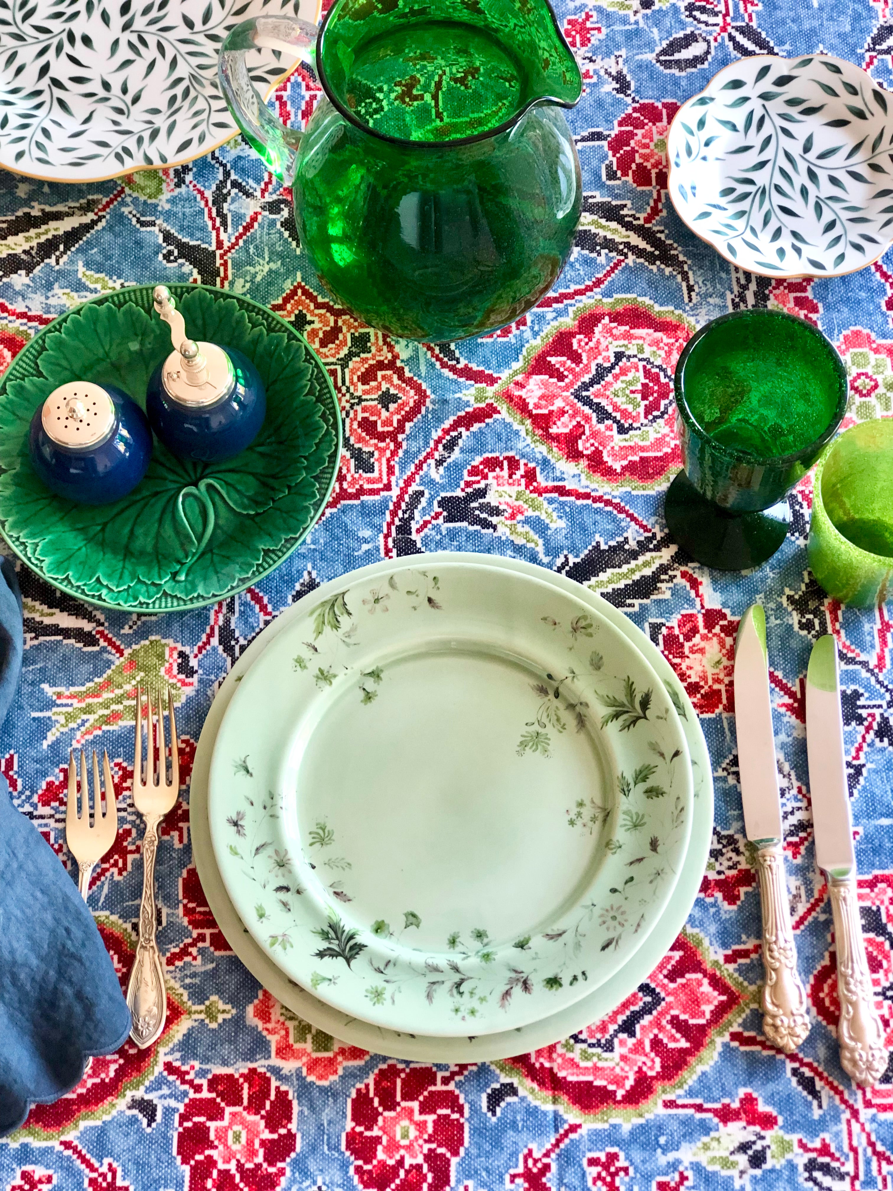 blue linen tablecloth with navy, burgandy and red floral pattern with light green placesetting