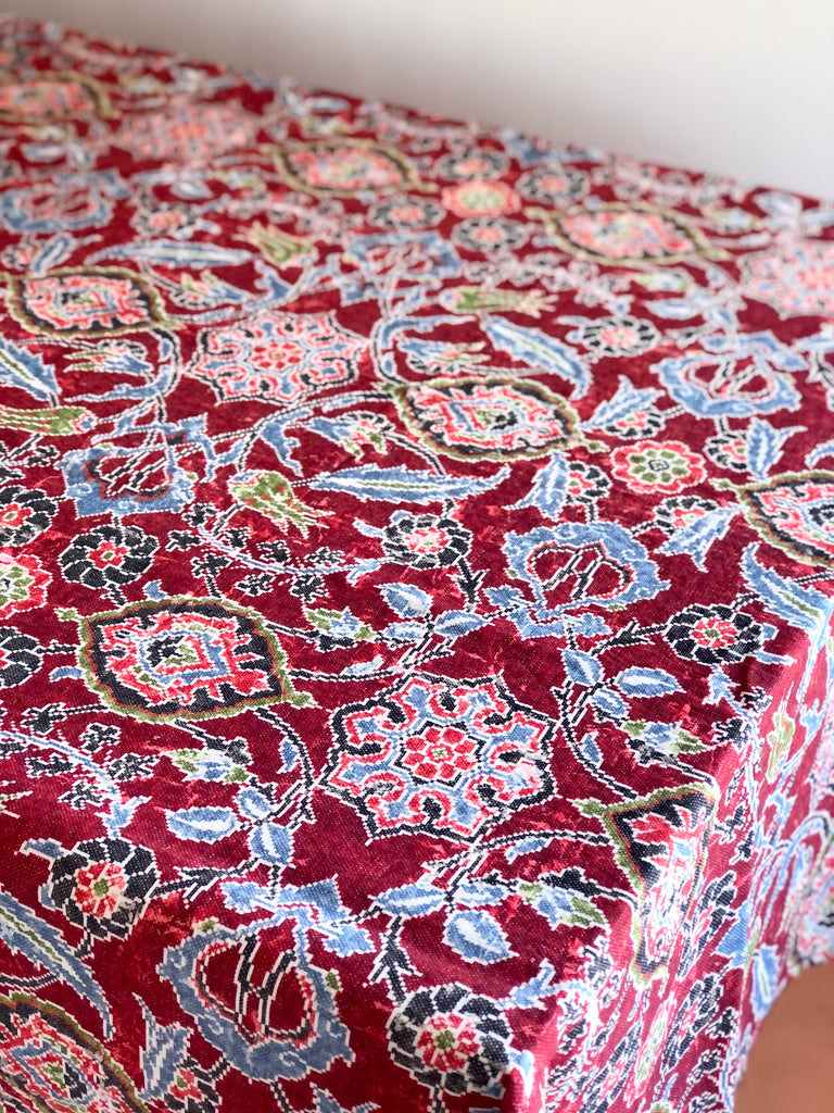 red linen tablecloth with navy, dusty blue and light red floral pattern on table
