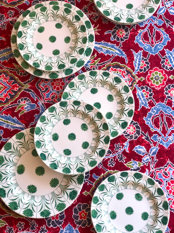 red linen tablecloth with navy, dusty blue and light red floral pattern with green and white plates