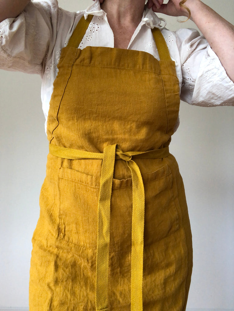 full length linen apron in mustard color close up view