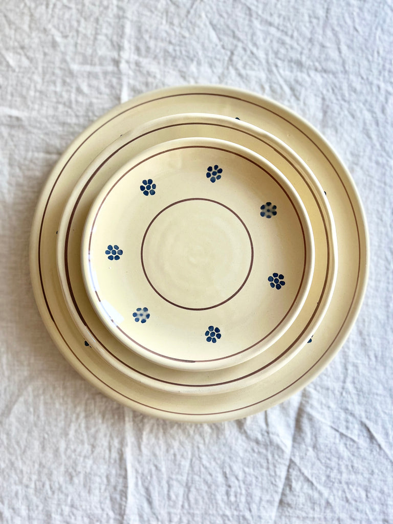 hand painted salad plate with brown rim and blue flowers around edge with dinner plate