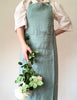 sage green linen apron full length pocket detail view