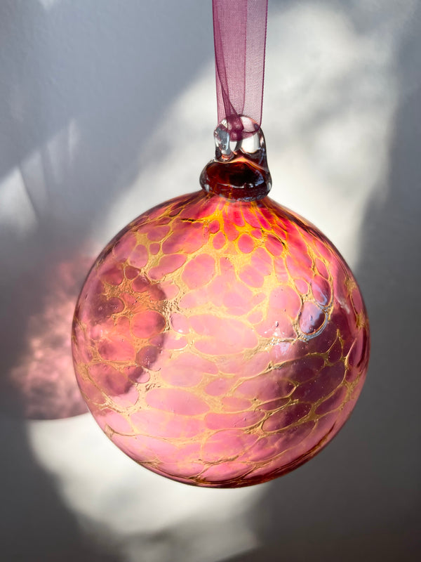 hand blown glass ornament with pink and yellow speckle pattern