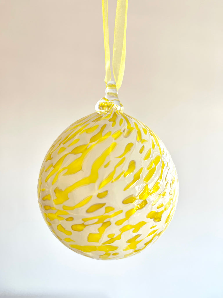 hand blown glass ornament with yellow and cream speckle pattern