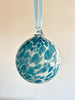 hand blown glass ornament with blue speckles hanging