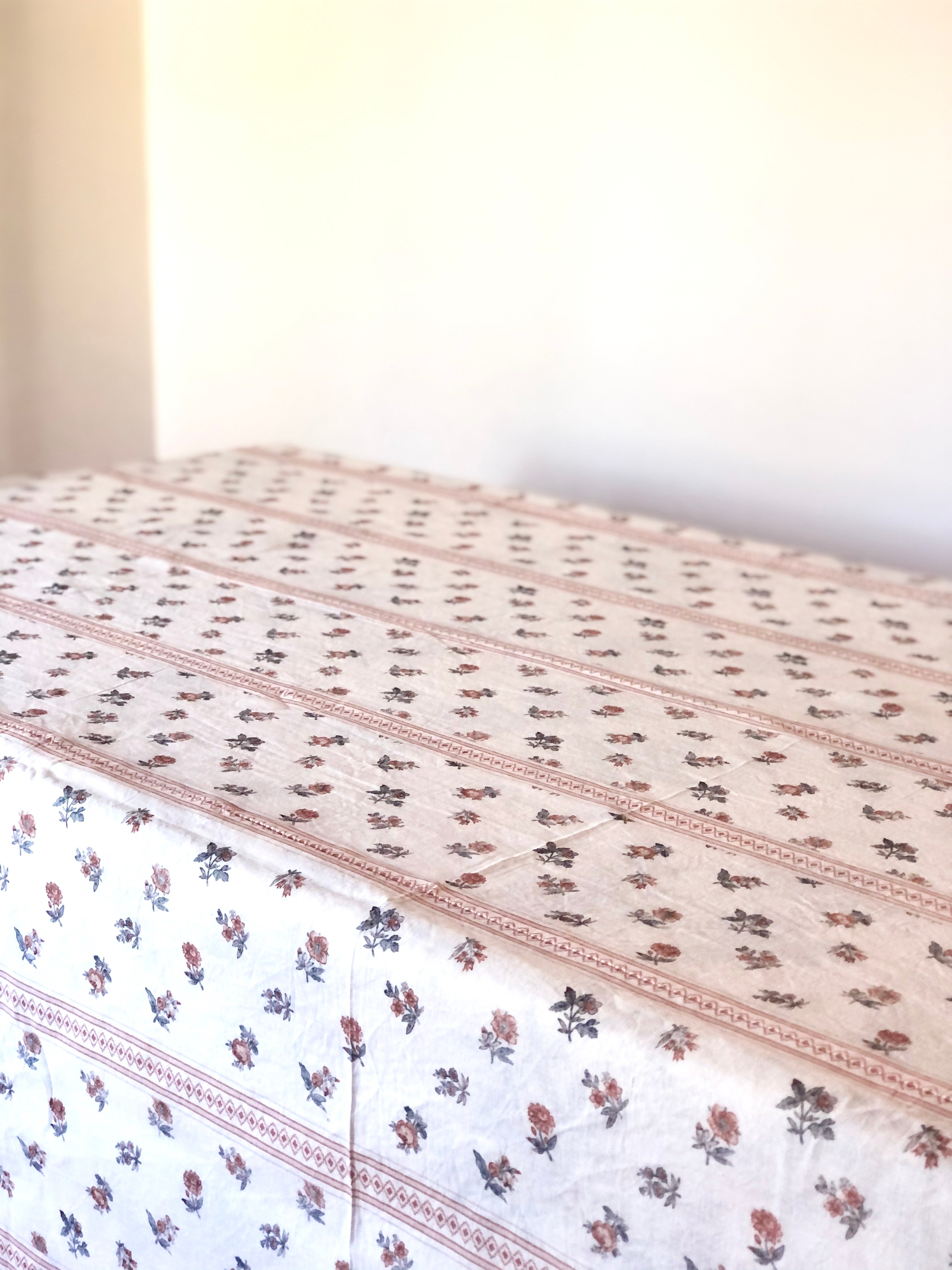 white tablecloth with red pinstripe and red floral pattern on table