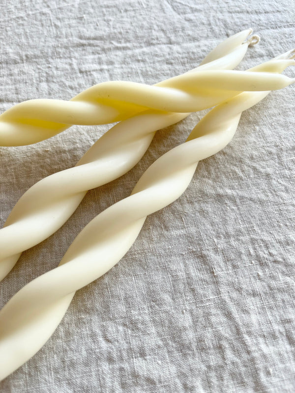 close up of white hand-crafted twist taper candles