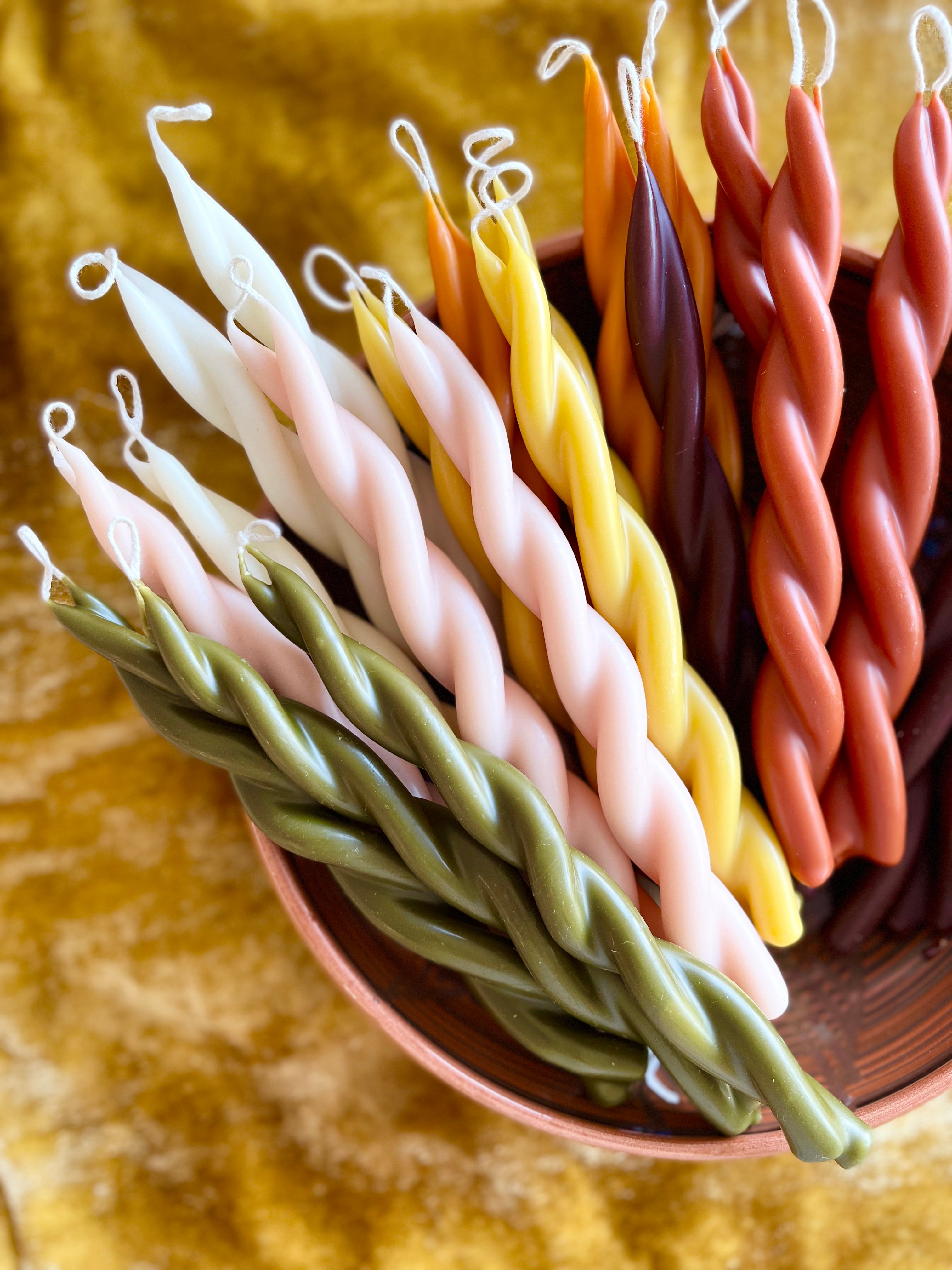 twisted candles by wax atelier multicolor tapers in stoneware bowl