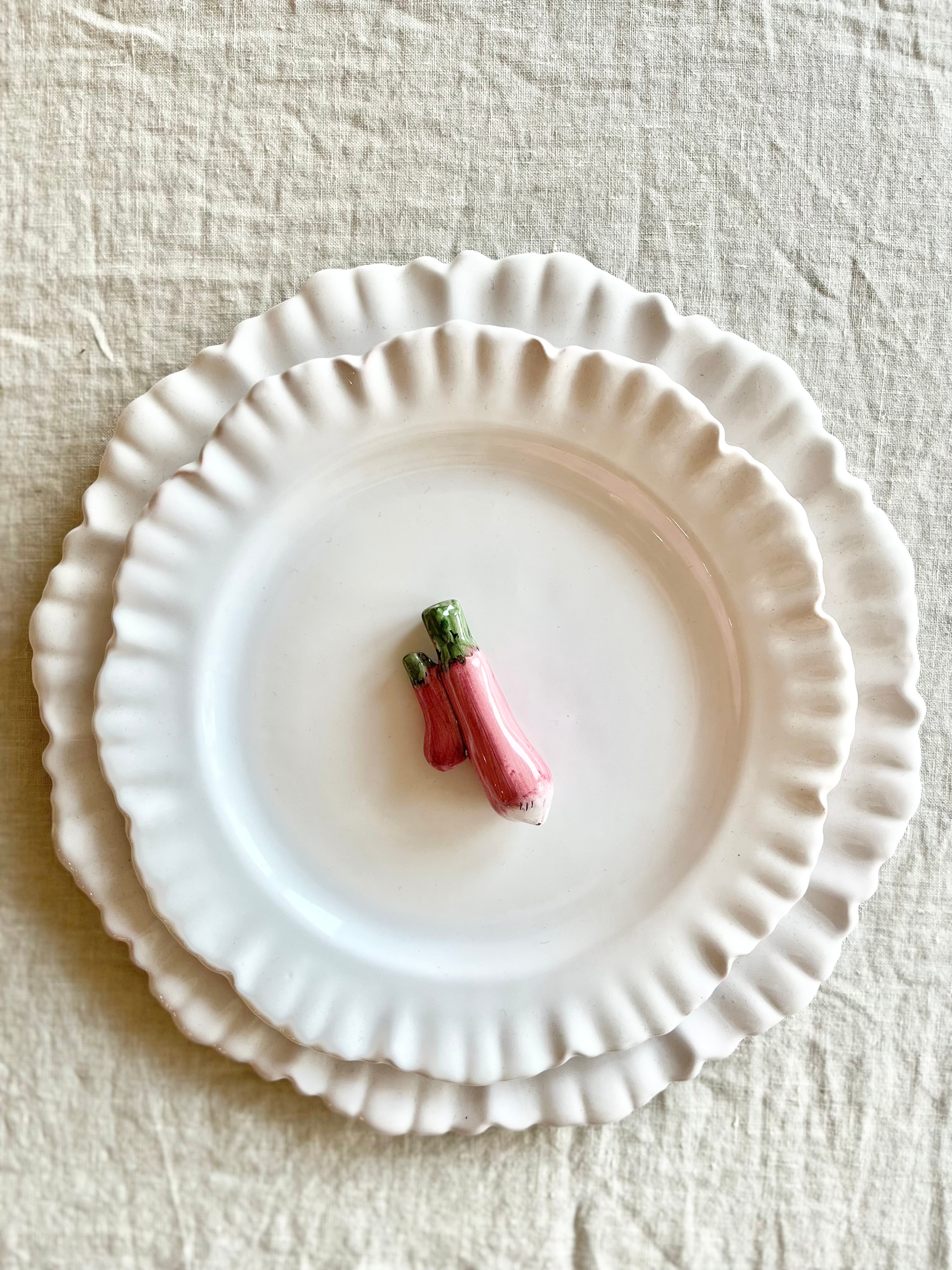 eggplant shaped ceramic knife rest detail on white plate 2.5 inches long