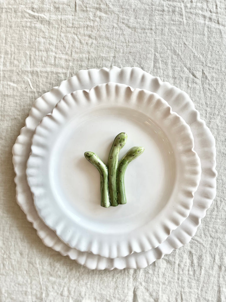 asparagus shaped ceramic knife rest detail on white plate 2.5 inches long