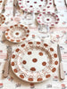 white ceramic dinner plate with brown daisy pattern with placesetting
