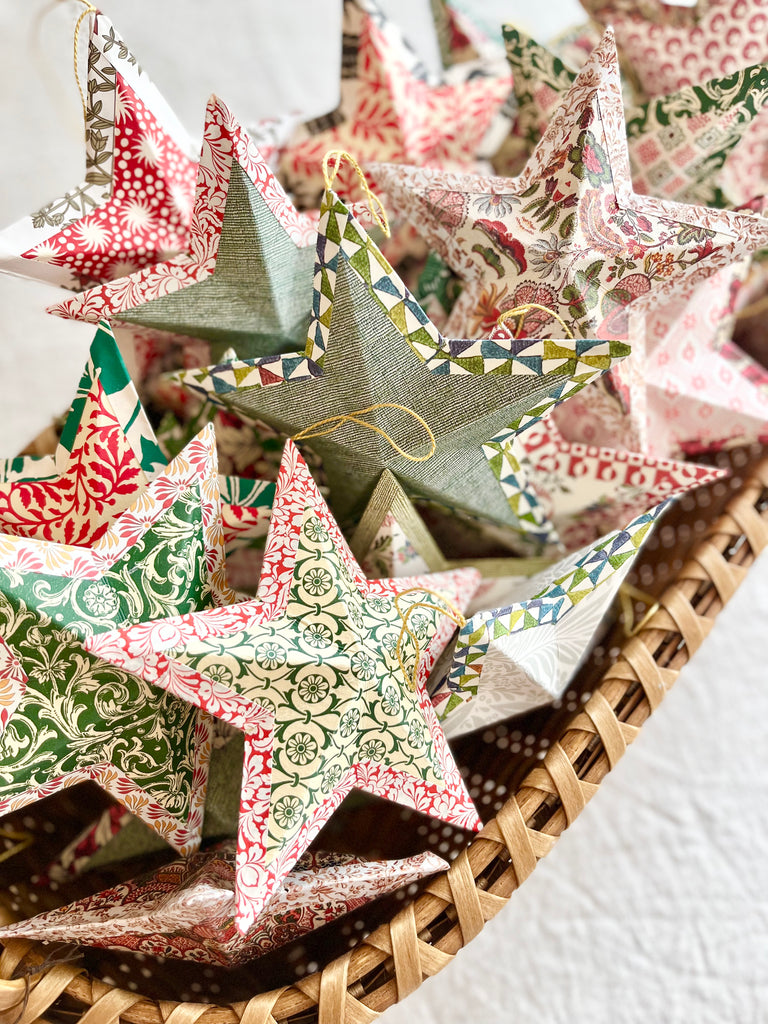 star shaped paper christmas ornaments in shades of green grouped in basket