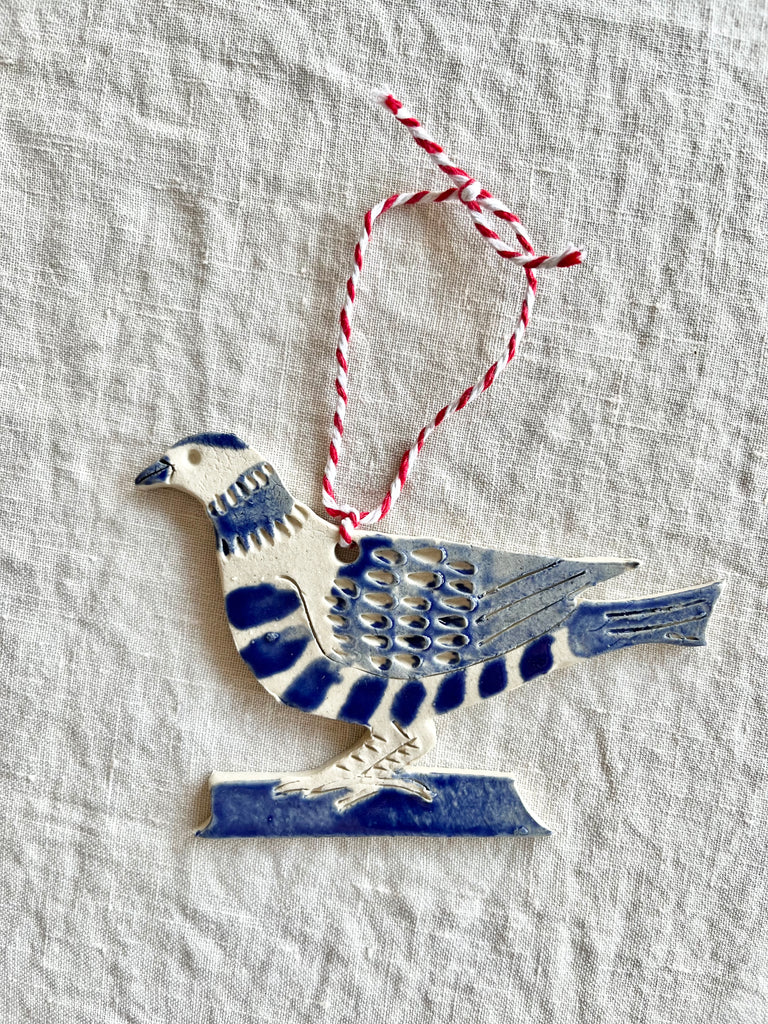 hand painted blue and white bird christmas ornament on white table