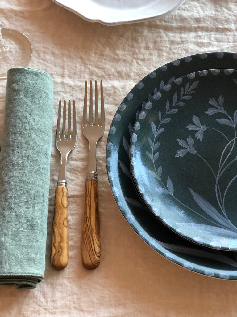 green dinner plate with hand painted white floral design with salad plate