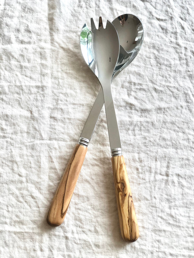 salad servers with olive wood handles on white linen