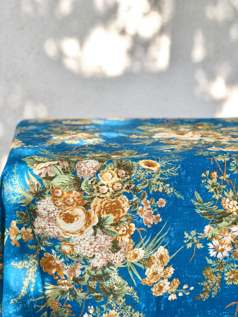blue tablecloth with cream white and light brown floral pattern