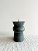 small dark green totem candle on table