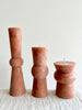 terra totem candles in various sizes tall medium and small on a table