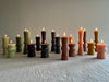 assorted totem candles green wine light pink on table with flame