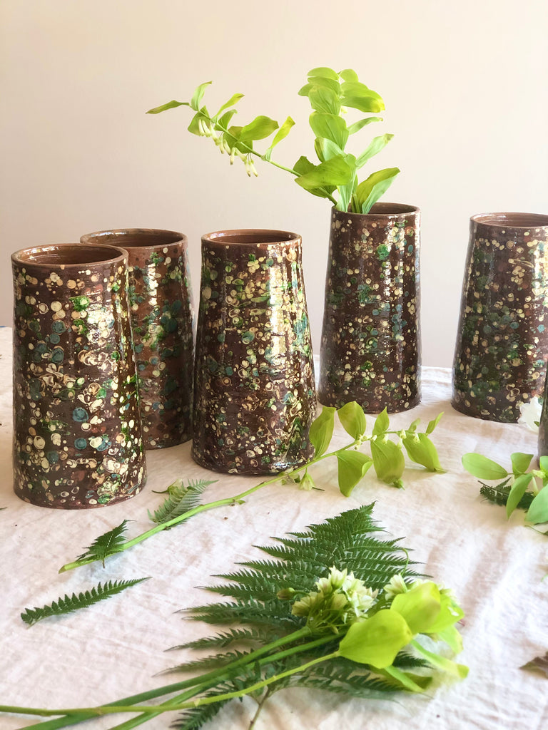 brown cylinder vases with green and cream speckle pattern 8.5 inches tall with greenery