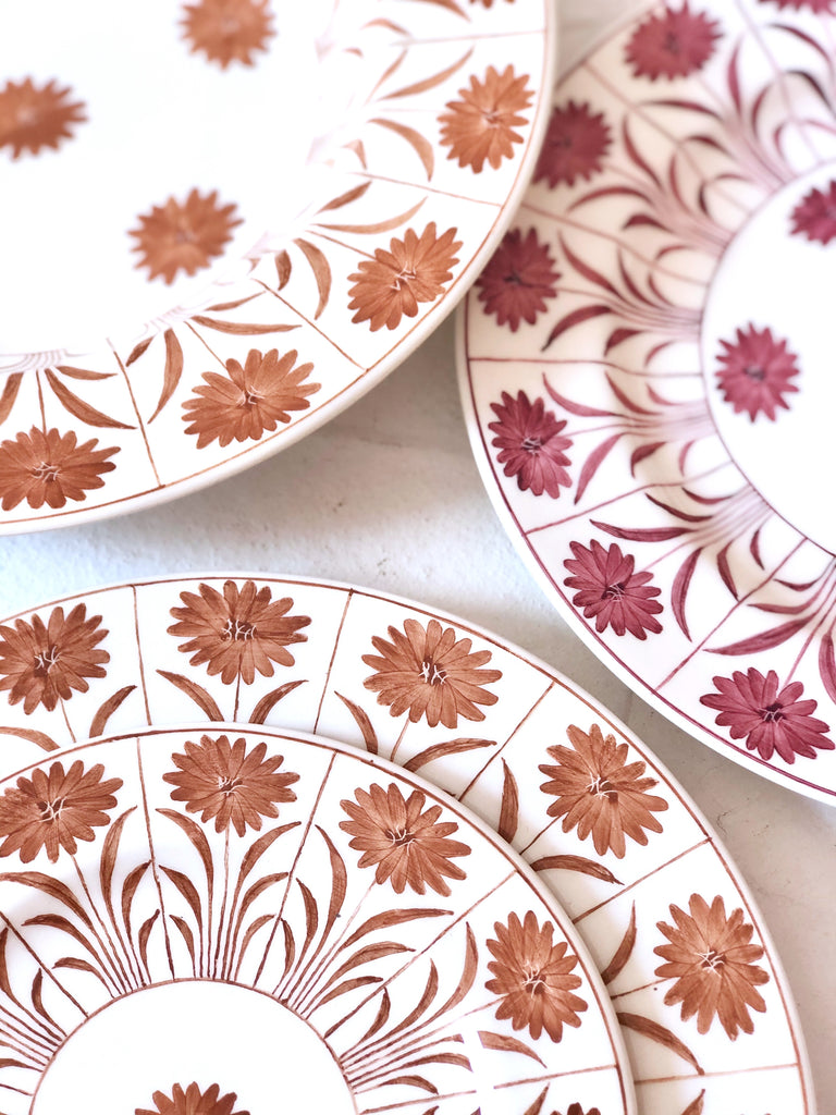 white ceramic dinner plate with brown daisy pattern detail view