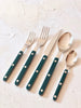 sabre stainless steel flatware set with teal resin handles on white table