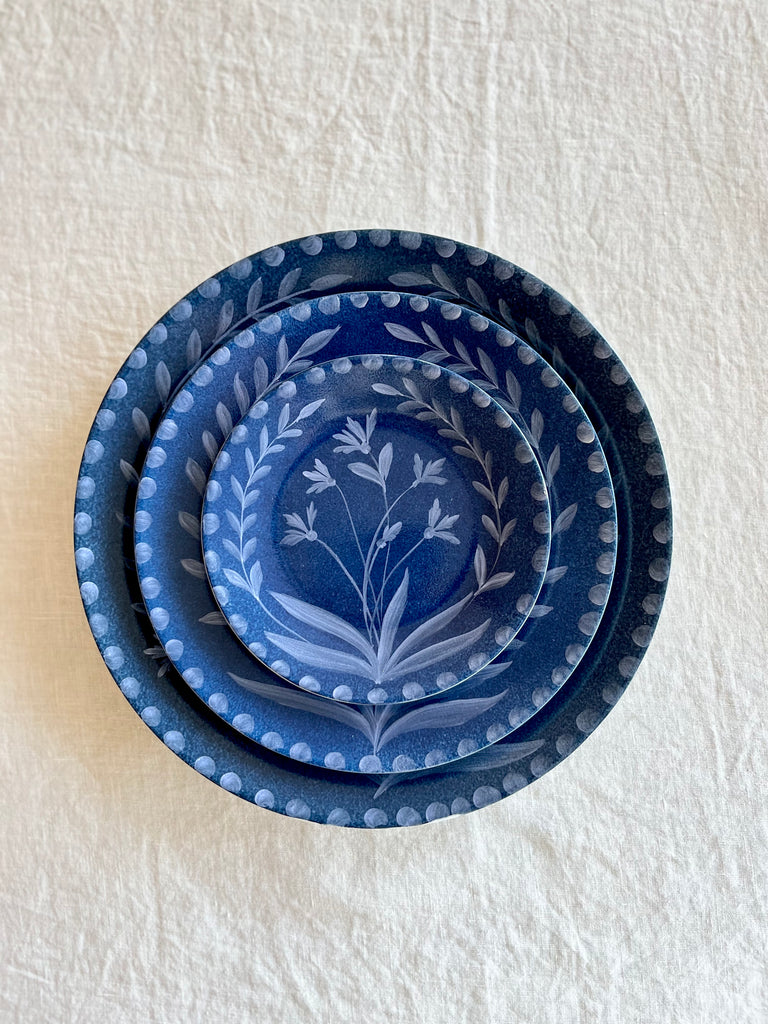 blue dinner plate with hand painted white floral design with salad plate and bread plate
