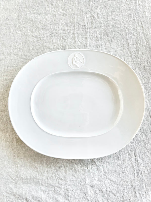 white oval serving platter with greek god medallion