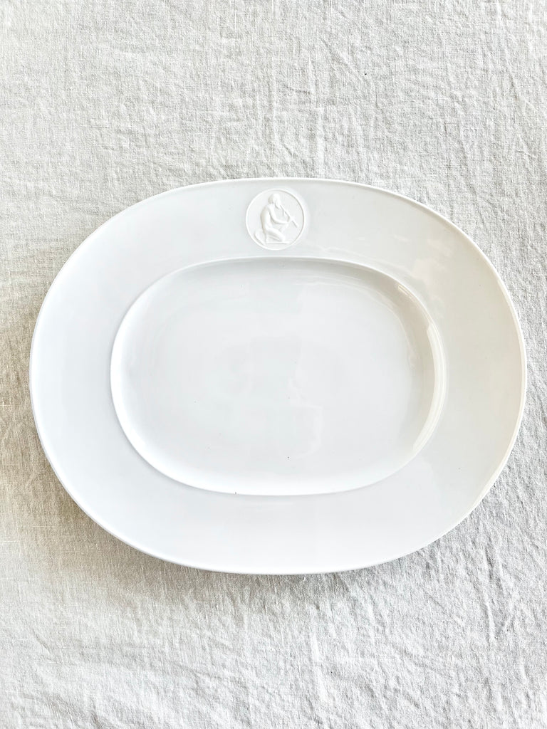 white oval serving platter with greek god medallion