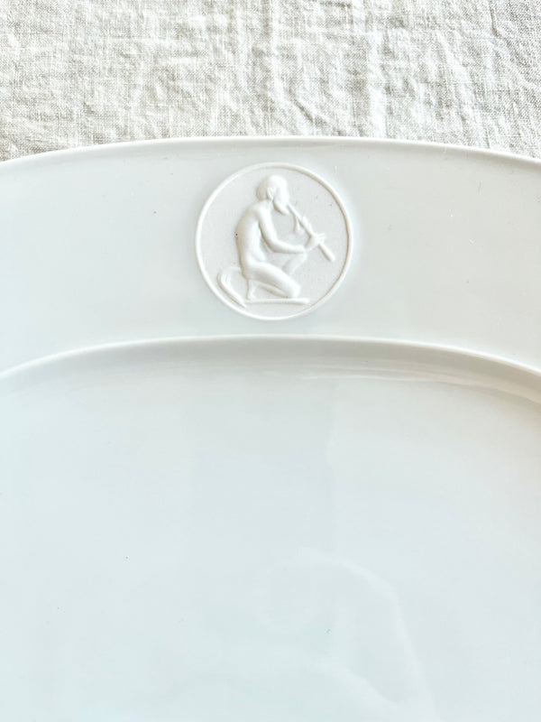 white oval serving platter with detail of greek god medallion